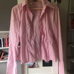 Rosa skjorta  - Rosa skjorta men lite längre flikar, och slits vid ärmslutet. Köpt på Sellpy. Aldrig använd.