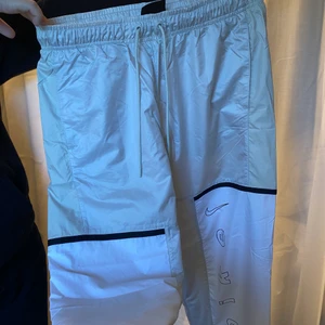 Nike byxor - Beige, svart vita byxor från Nike. Tryck på låret & på baksidan. Supersköna & luftiga. Köpt för 799kr. Skriv för mer information eller bilder ☺️