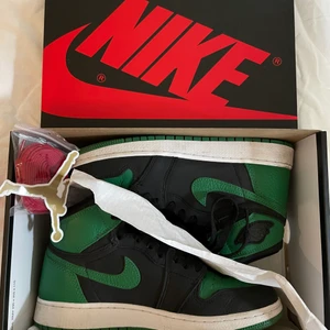 AIR JORDAN 1 RETRO HIGH BLACK/PINE GREEN - Säljer nu mina Jordans då de ej kommer till så mycket användning som de förtjänar. Skitsnygga och i jättebra skick. Det ända är att sulorna är lite smutsiga. Köpta på UNLIMITED COPENHAGEN. Kommer sälja till den som budar högst men start bud från 2000kr. Sen är det Spårbarfrakt på 66kr! Storleken är 38,5