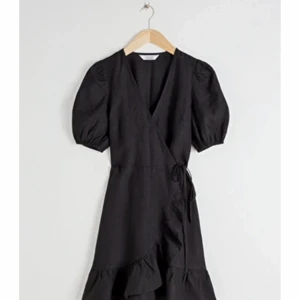 Vacker klänning från otherstories - Skit snygg svart wrapklänning i svart med volanger på botten. Den är från otherstories och har aldrig använts då jag köpt fel storlek (för liten). 💕