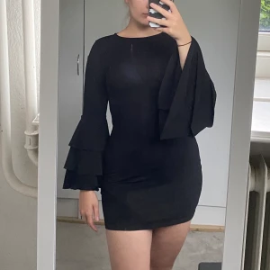 Festklänning från Gina Tricot - En klassisk, svart festklänning från Gina med volanger på armarna. Framhäver kroppen utan att vara tajt med ett stretchigt tyg. Kan upplevas som lite genomskinlig om man har vitt under som jag har på bilden, men har man svarta underkläder ser man inget. För referens är jag är 1,73 cm lång, har 40 i byxor och s/m topp✨