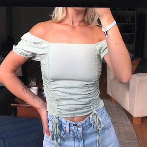 Fin offshoulder/topp - Ljusgrön/”dusty green” färgad topp som egentligen sitter som en smäck, tyvärr har den aldrig kommit till användning av någon anledning. Reglerbara snören så du kan göra den croppad eller lite längre. Pris inkl frakt (vill du ha spårbart tillkommer det)