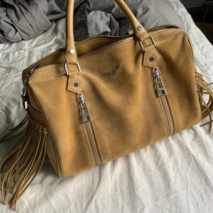 Zadig & voltaire väska  - Säljer min väska från Zadig & Voltaire i modellen Sunny bag, i storlek medium, köpt för lite över 4000kr. Bra skick. Finns även ett långt band med som man kan sätta på väskan och ta av. Dustbagen får man med. vanlig frakt 100kr, spårningsbar frakt 191kr. 