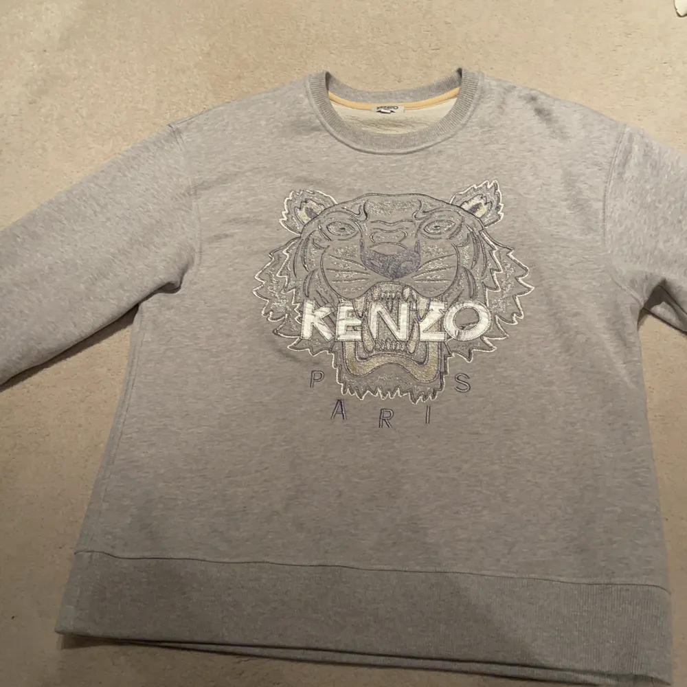 Neutral och snygg grå kenzo sweatshirt. Använt en gång typ och har inte använt den på länge. Den har grå och silvriga detaljer. Den är inte så skrikig som många andra kenzo plagg vilket gör att den passar oavsett säsong💜. Tröjor & Koftor.
