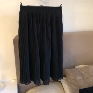 Svart refflad kjol NA-KD strl 36 - Oanvänd refflad kjol från NA-KD. Inga fläckar eller lösa trådar.Skriv för mer frågor, om leverans väljs står kund för frakt kostnader