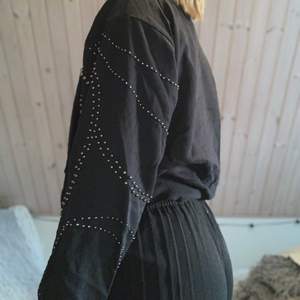 Svart tröja med ballongärm och svarta”stenar” på armarna. Är köpt på Lindex och är gjord i ett väldigt skönt material!!