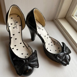 Svarta klackar storlek 35/36 - Sparsamt använda klackskor med rosett i storlek 36 men skulle kunna passa en med storlek 35 då modellen är smal 