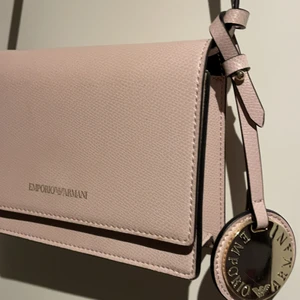 Emporio Armani väska - Söt lite väska kan användas som clutch oxå går att ta bort bandet. Givetvis äkta köptes på zalando. I fint skick som ny. Liten väska. Buda i kommentarerna! Nypris för att vara exakt 1395kr