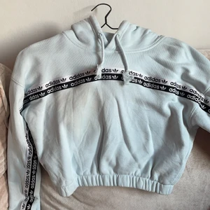 Adidas crop hoodie  - Använd 1-2 gånger, inköpt på Adidas store kungsgatan 2021. Stl S/36. Ljus blå färg