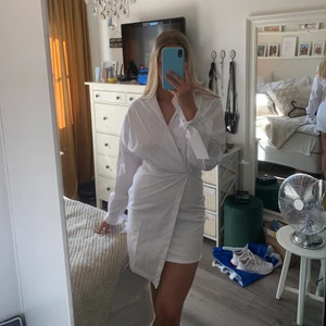 Klänning  - Så snygg vit klänning från NAKD. Klänningen har knyte runt handlederna, snygg passform och dragkedja längst ena sidan. Klänningen är i storlek 36 och endast använd en gång men kommer tyvärr inte till någon användning längre. Frakt tillkommer🥰