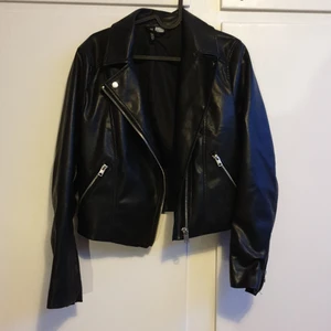 Skinnjacka str.36 - En svart skinnjacka i fake skin från hm. Str.36. Silver dragkedjor. Använd fåtal gånger.