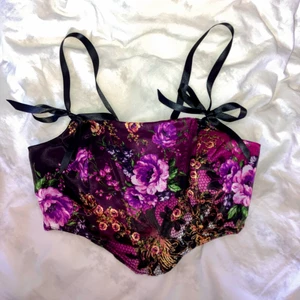 Korsett topp - Säljer en korsett topp i fint blommigt tyg som går från rosa-lila till svart. Satinbanden vid axlar och rygg är reglerbara för att ge bäraren perfekt passform. Passar en midja mellan ca 60-70 cm Pris: 600 kr Sydd av mig, följ @tizzily på instagram för fler kläder sydda av mig.