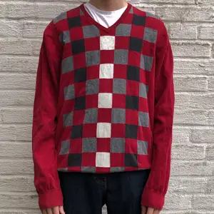 En röd långärmad tröja med ett svart, vitt och grått mönster på framsidan. Priset inkluderar inte frakten. Tar swish.