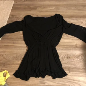 Svart jumpsuit storlek xs -  Svart jumpsuit i storlek XS. Säljer pga att den inte används, använd ett fåtal gånger utomlands. Perfekt till sommaren. Mönster vid armarna och knappar vid bröstet så den går att knäppa.