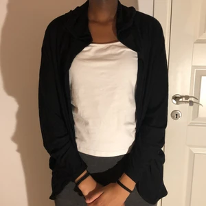 Svart kofta i storlek S - Svart kofta med luva. Fin med linne under, säljer pga att den inte används hos mig. Skönt material, storlek S.