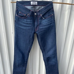 Acne studios jeans - Mörkblå jeans med röda sömmar, från acne studios Storlek 28/32. Innerbenslängd: 77 cm. Midjemått: 34 cm rakt över. 