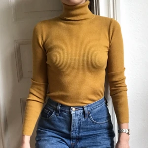 Gul polo i ull från Uniqlo strl 34 - Senapsgul polo/turtle neck i 100% ull från Uniqlo. Ribbad, ganska tunn. Otroligt skön (mjuk, inte stickig) och välskuren. Jag är strl 34 och den sitter bra på mig!