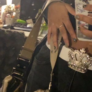 SUPERSNYGGT Y2k BÄLTE - Asballt vitt y2k (victoria Beckham inspirerat) vintage bälte med silverkrona med glittrande rhinestones i! Man kan göra egna hål i bältet för att det ska passa perfekt💕