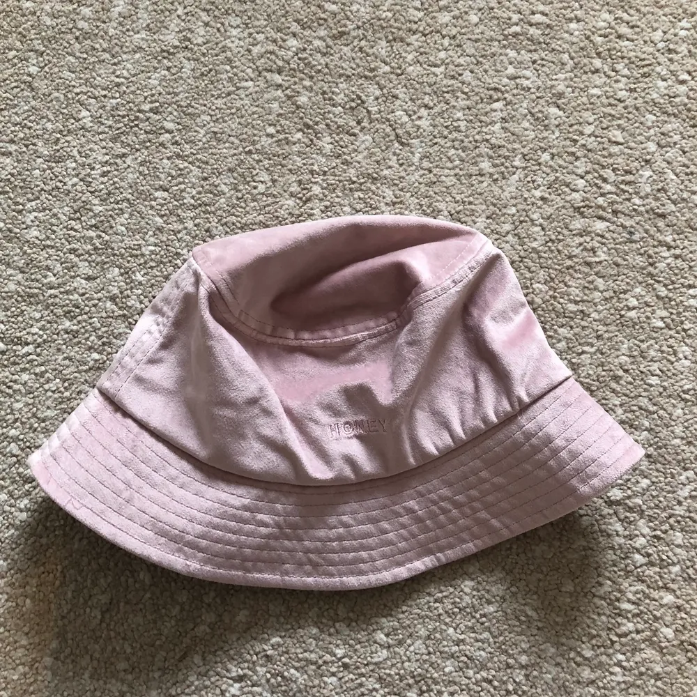 Ljusrosa buckethat från Berska med texten ”Honey” på framsidan. I fint skick 💖. Accessoarer.