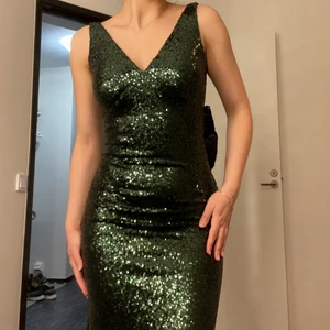 Fest klänning  - Glittrig grön fest klänning som är bara en gång använd 4h. Väldigt fin klänning med spets och öppen rygg.