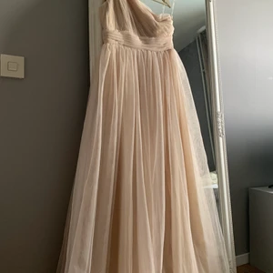 Fest klänning från Nelly.com - En super vacker lång klänning med one shoulder i storlek 38. Aldrig använd och säljes pga inget tillfälle att använda den på. Köpt för 400 kr.