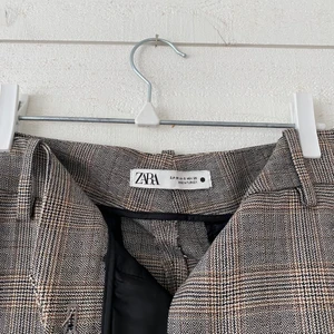 Rutiga kostymbyxor från Zara, str38 - Snygga och oanvända kostymbyxor från Zara, säljs då dom aldrig kommit till användning:/ Mönster syns bäst på första bilden🤎