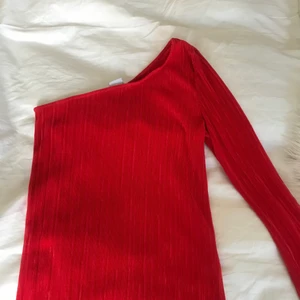One shoulder topp - Röd topp men bar axel. Använd fåtal gånger och är i bra skick. Snygg till sommaren!