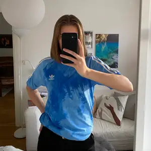 En blå t-shirt från adidas herravdelning i blått, tie dye liknande mönster. I bra skick. Köpare står för frakt.