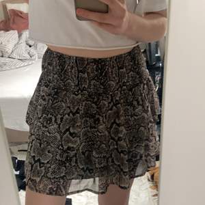 En fin kjol från kaphal skulle säga att det är ormskinsmönster. köpt för kanske ett år sen men inte använd mer en två gånger pågrund av inte riktigt min stil. Storlek 158-164❤️