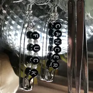 Örhänge med svarta pärlor med texten ” fuck cancer” och vita runda pärlor 🟢finns i lager 