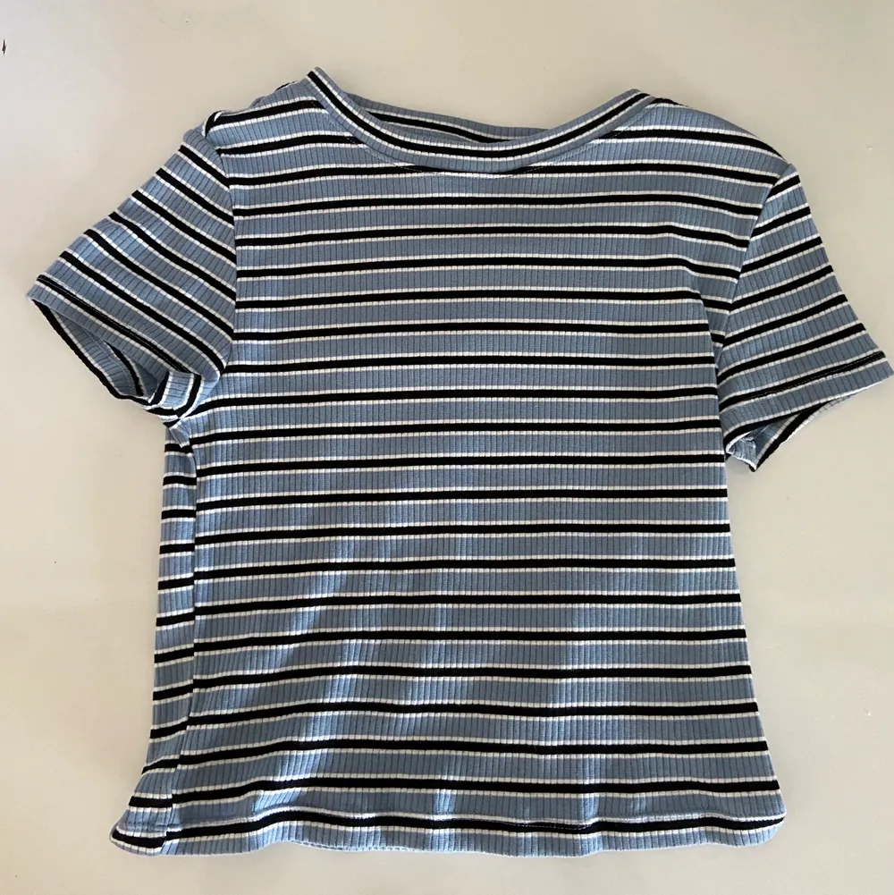 En blå t-shirt med svarta och vita ränder i storlek: S  Frakt: 15kr 🤍. T-shirts.