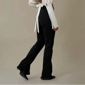 Svara jeans med slits - Ett par svarta jeans med slits på sidan. De är helt slutsålda på NA-KD. Dem är i storlek 36 men skulle säga att dem testar en 34:a också. Dem är aldrig använda