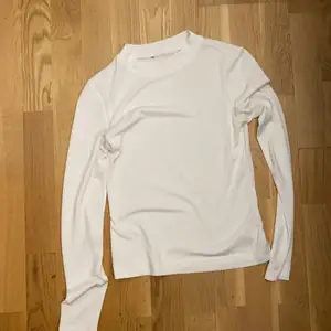 En vit långärmad tröja i storlek XS. Tajt tröja och tajt krage. Använd 1/2 gånger för ca 2/3 år sen. Finns även i svart, XS.