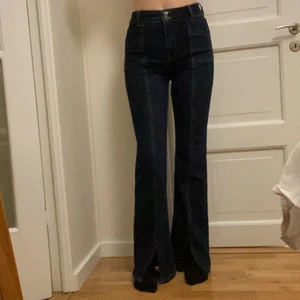 Utsvängda jeans med sömmar - Högmidjade utsvängda jeans med så fina detaljer o slits nere vid fötterna. Dom är i st M men passar också S, jag är 1,75! Bara att skriva om man vill ha fler bilder! 