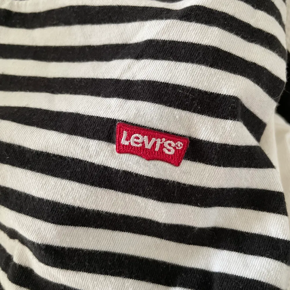 Snygg randig tröja från Levi’s med logga på bröstet. Väldigt bra skick. Spårbar frakt med DHL inräknat i priset!!. T-shirts.