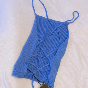 Topp med öppen rygg - Jätte gullig blå topp med knytrygg. Väldigt mjuk i materialet. Tyvärr för stor för mig så helt oanvänd. Den är i storlek one size men skulle kanske gissa på att den passar M. Säljs för 50kr+frakt 