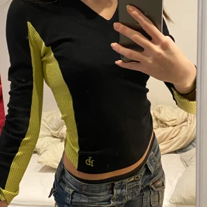Tröja - Svart tröja i lite tjockare material med grönt på sidan. Jätte skönt material, varm och sitter tajt men är även stretchig. Storlek S/M