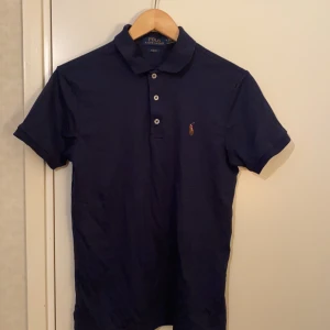 Piké från Polo Ralph Lauren.  - Marinblå kortärmad piké från Polo Ralph Lauren som är i nyskick, använd några gånger. Broderad logga på vänster bröst. PRIS KAN DISKUTERAS!!!