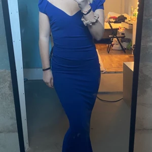 SNYGG LÅNGKLÄNNING - Säljer nu min klänning som jag hade på min bal, den är alltså använd en gång och är i superbra skick!! Som man ser är den lite utsvängd, sjöjungfru aktigt, nertill och tajt på resten av kroppen💜💜 kom med bud!!! Kommer ifrån GODDIVA LONDON, storlek 8 i UK. 