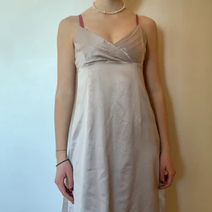 Klänning - En vacker klänning!! Glansigt material med beige färg. Perfekta längden och väldigt snygg passform. Köpt på secondhand men har aldrig använt den, så den är i gott skick! 