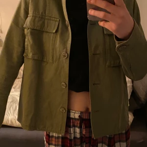 jacka - här är en grön tunn jeans jacka som är perfekt inför våren. Den har en mer militär grön färg i verkligenheten. Inte så använd, bra skick.