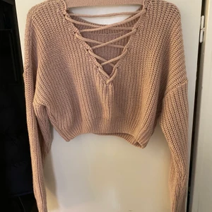 Stickad kort tröja i rosa stl S - Kort stickad tröja i rosa stl S, öppen i ryggen och med snörning bak. Passar såväl till jeans som till träningsoutfiten. I princip aldrig använd.