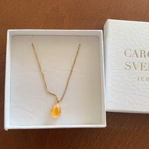 Säljer ett oanvänt halsband med gul sten från Caroline Swedbom. Kedja ca 50cm. Nypris 595kr
