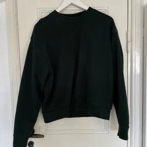 Grön sweatshirt  - Snygg grön sweatshirt från Weekday som är i bra skick tack vare använd fåtal gånger. Väldigt oversized, sitter stort på mig som vanligen är S/M så den passar många storlekar. Smutsig spegel på andra bilden. Spårbar frakt med DHL inräknad i priset!!