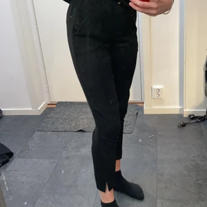 Svarta kostymbyxor med slits - Svarta kostymbyxor med söm i mitten och en slits och igensydda fickor där bak, men som är för små