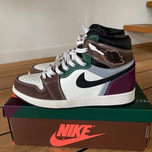 Nike Air Jordan 1 High OG “Hand Crafted - Jordans köpta i december 2021 från Nike Store. Jag fick dem i julklapp och  har blivit använde 2 gånger. Andledning till att jag säljer dem är att de är för små. Det är storlek 42. Pris kan diskuteras då budgivning är möjligt. Sko box ingår. 