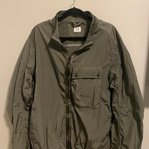 C.P Company Jacka - Chrome Re-Colour Popover Goggle Jacket. Skit snygg vår jacka. Slutsåld nästan överallt och nypris ligger runt 3500-4000kr. Den är använd fåtal gånger och har inga flaws. För fler bilder och funderingar, hör av er! (Priset är ej hugget i Sten)
