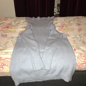 Vila  - En ljus blå stickad tröja som man kan ba offshoulder 