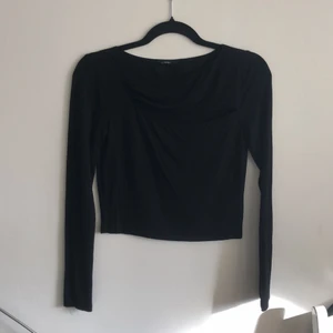 Svart tröja - Svart långärmad tröja med öppning över bröstet. Ny skick.