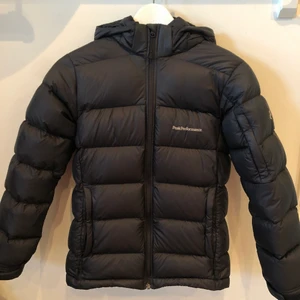 Peak Performance Jacka strl 160 - Svart Peak Performance dunjacka i mycket fint skick, storlek 160 cm. Sparsamt använd. Säljer för att den har blivit för liten. Finns att hämta i Täby eller skickas mot fraktavgift.